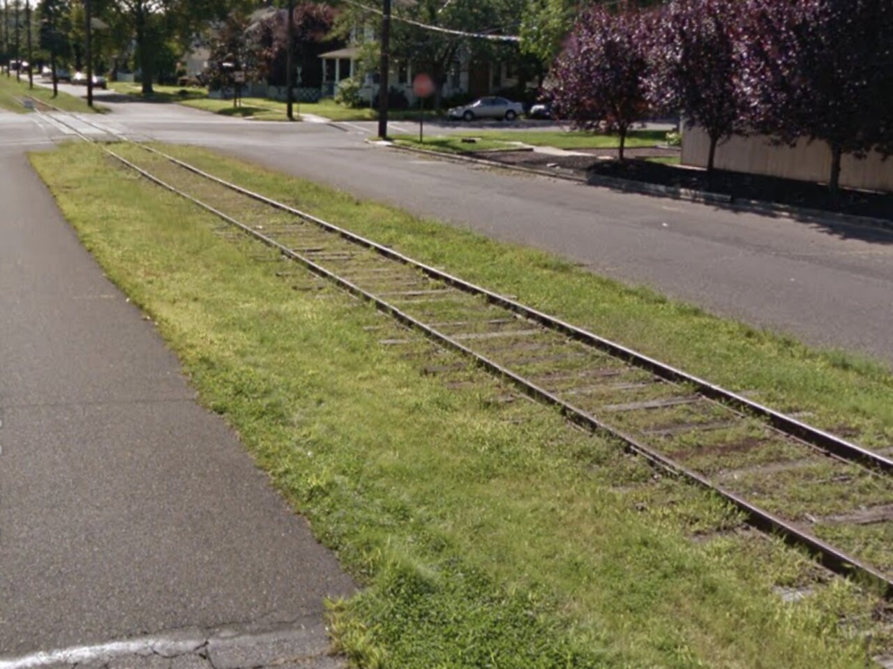Abandoned railroad tracks from Griffin Pipe era in 2013, showing overgrown grass and old tracks along East 5th Street