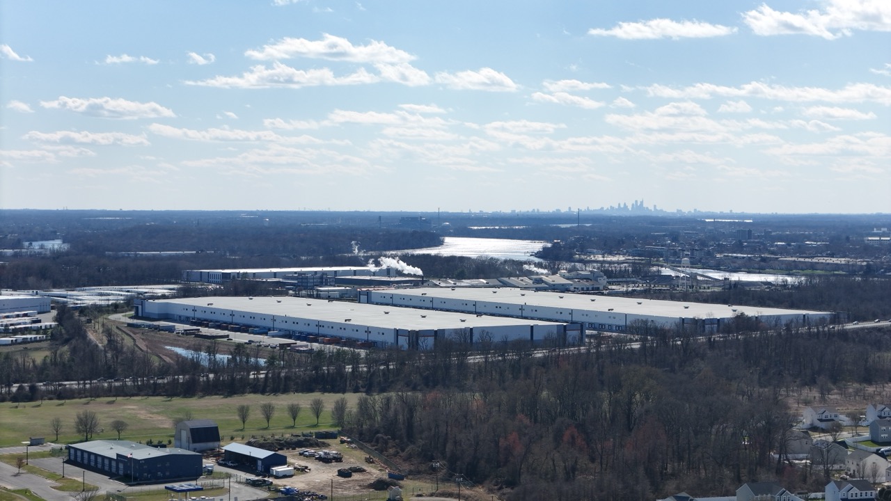 Aerial drone view of warehouse development along I-95 corridor near Florence Township, showing massive distribution facilities and truck staging areas